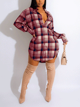 Woman wearing a burgundy and navy plaid shirt dress with thigh-high beige boots and a light beige handbag, front view.