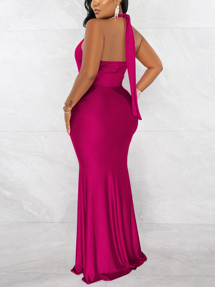 Back view of a woman in a long fuchsia mermaid dress with a halter tie