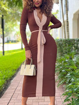 Woman wearing a long-sleeved, bodycon midi dress with brown and beige color-blocking and a matching belt, standing outdoors.