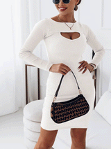 Woman wearing a white long-sleeved bodycon dress with a cut-out neckline and a patterned handbag.