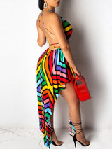 Back view of a woman in a multicolored striped halter dress with an asymmetrical hemline.