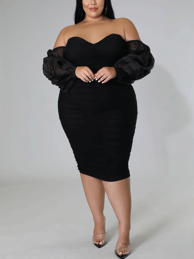 Woman wearing a black off-the-shoulder ruched midi dress with sheer puff sleeves.