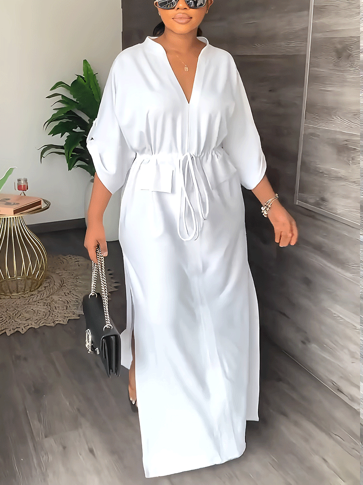 Woman wearing a white V-neck maxi dress with a drawstring waist and side slits.