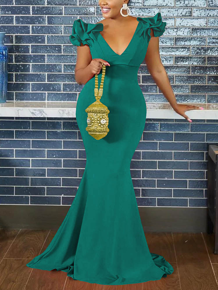 Woman wearing a teal mermaid-style formal gown with ruffled cap sleeves and a deep V-neckline.