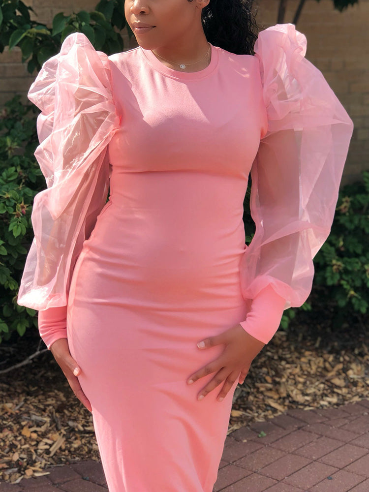 Close-up of a woman wearing a pink dress with sheer puff sleeves