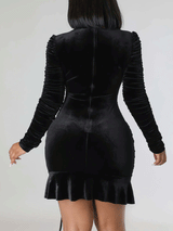 Back view of a woman in a black velvet ruched dress.
