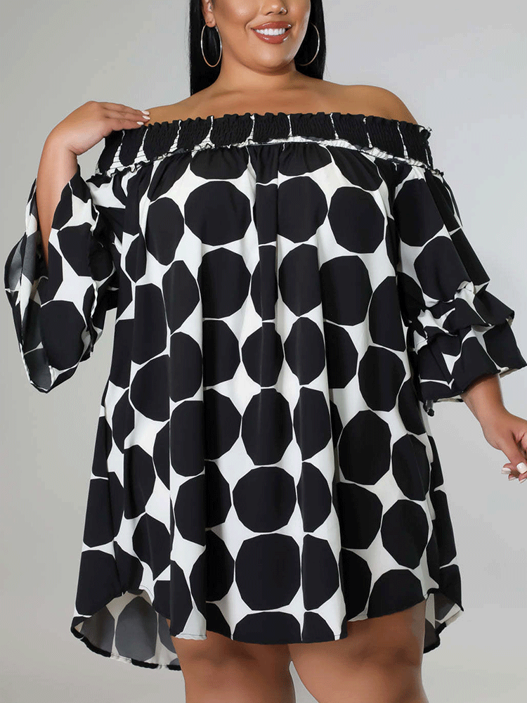 Woman wearing a black and white polka dot off-the-shoulder dress with ruffled sleeves.