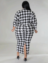 Back view of a plus size model in a black and white houndstooth print mock neck midi dress with a matching jacket