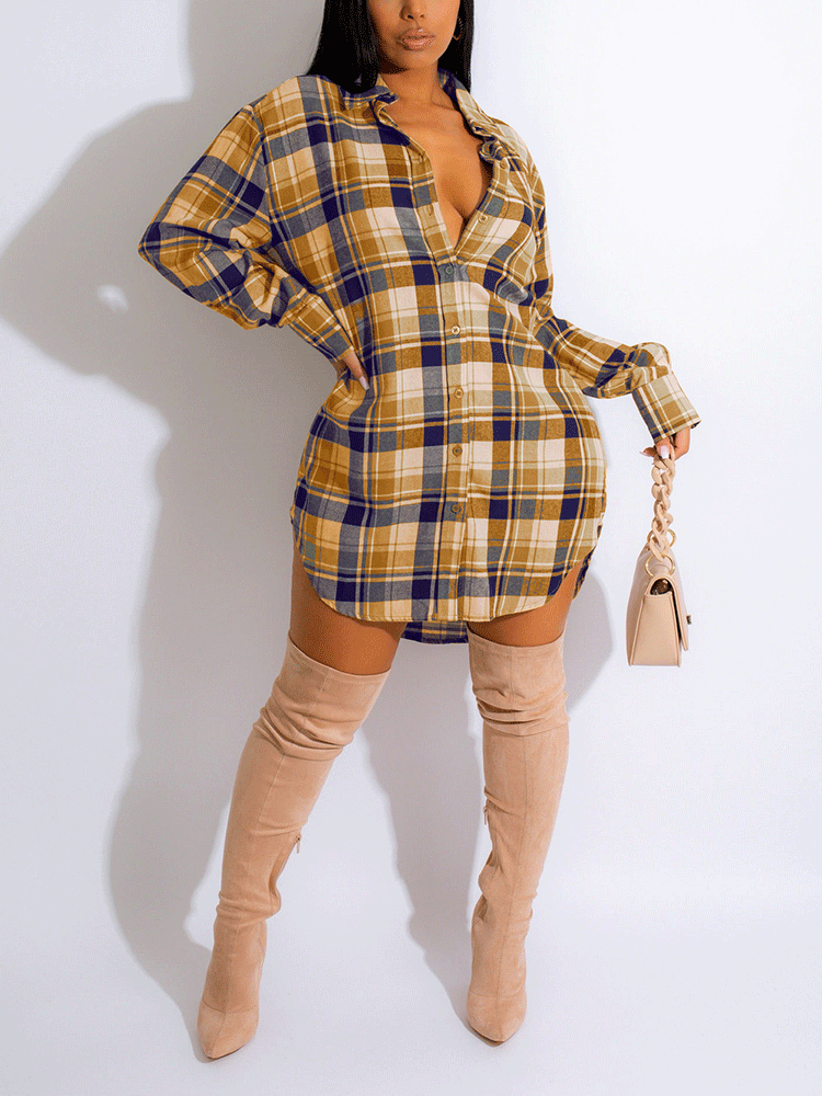 Woman wearing a yellow and navy plaid shirt dress with thigh-high beige boots and a light beige handbag, front view.
