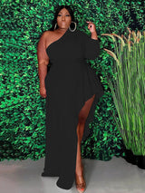 Woman wearing a black one-shoulder maxi dress with an asymmetrical hemline and ruffle detail.