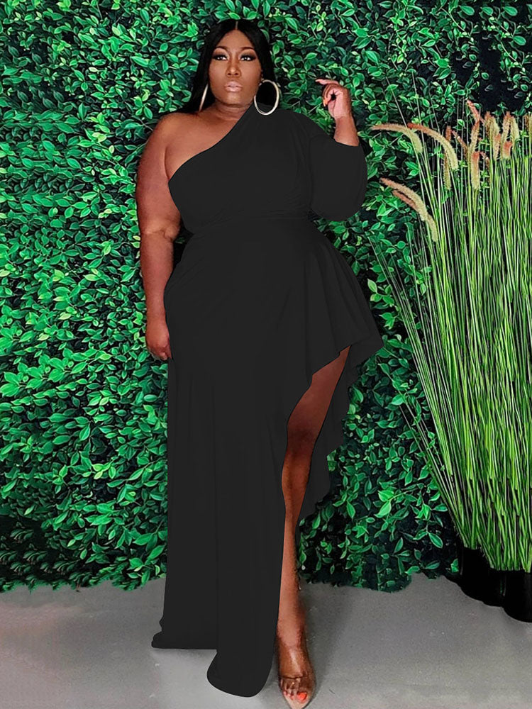 Woman wearing a black one-shoulder maxi dress with an asymmetrical hemline and ruffle detail.