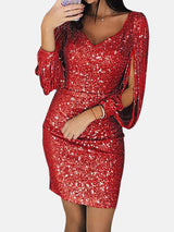 Woman wearing a red sequin dress with tassel sleeves