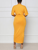 Back view of a woman wearing a yellow V-neck wrap dress with short sleeves and a fitted silhouette.