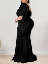 Side view of a woman in a black mermaid gown with puffed sleeves