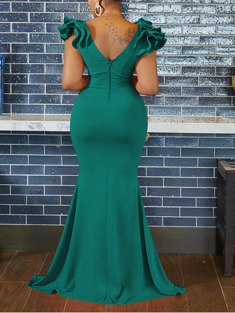 Back view of a woman in a teal mermaid-style formal gown, showing the zipper closure and ruffled cap sleeves.