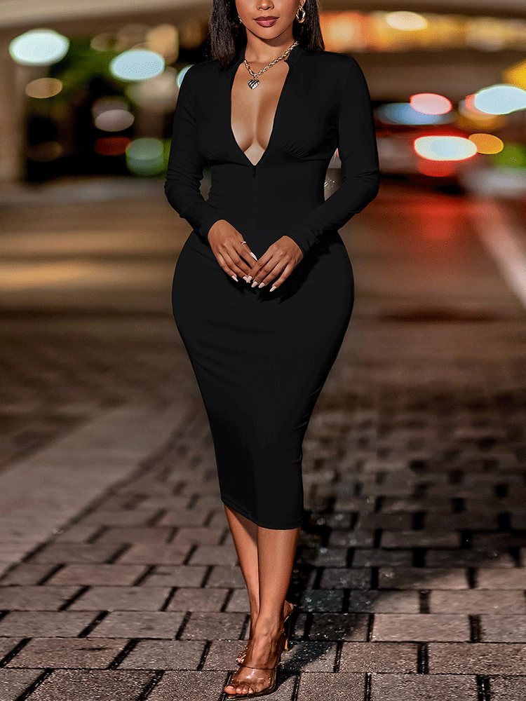 Woman wearing a black long-sleeved midi dress with a plunging V-neck and zip closure, standing outdoors at night.