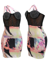 Front and side views of a black mesh dress with rhinestone embellishments and a colorful abstract print skirt