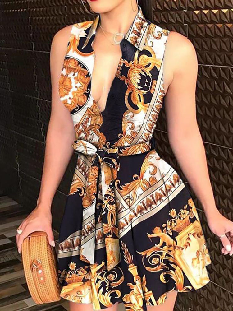 Woman wearing a sleeveless V-neck mini dress with a baroque print and tie waist.