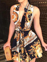 Woman wearing a sleeveless V-neck mini dress with a baroque print and tie waist.