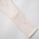 Close-up of the cuff of the long dolman sleeve on the off-the-shoulder mini dress.