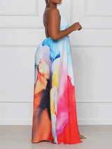 Side view of a woman showcasing the high slit and flowing skirt of an abstract print maxi dress.