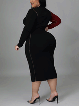 Back view of a plus size woman in a black midi dress with a burgundy sleeve