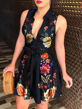 Woman wearing a sleeveless V-neck mini dress with a floral print and tie waist.
