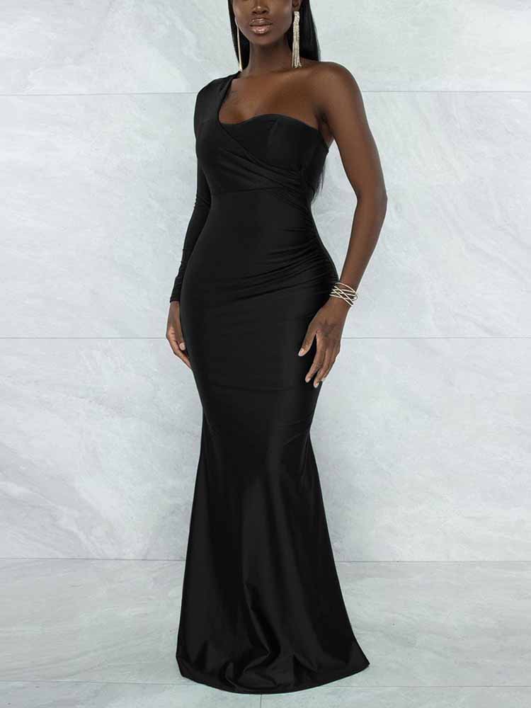 Side view of a woman in a black, one-shoulder formal gown with ruching details and a flowing mermaid skirt.
