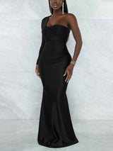 Side view of a woman in a black, one-shoulder formal gown with ruching details and a flowing mermaid skirt.