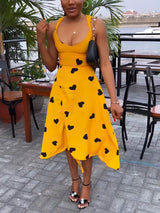 Front view of a woman in a yellow heart-print dress with ruched detailing.