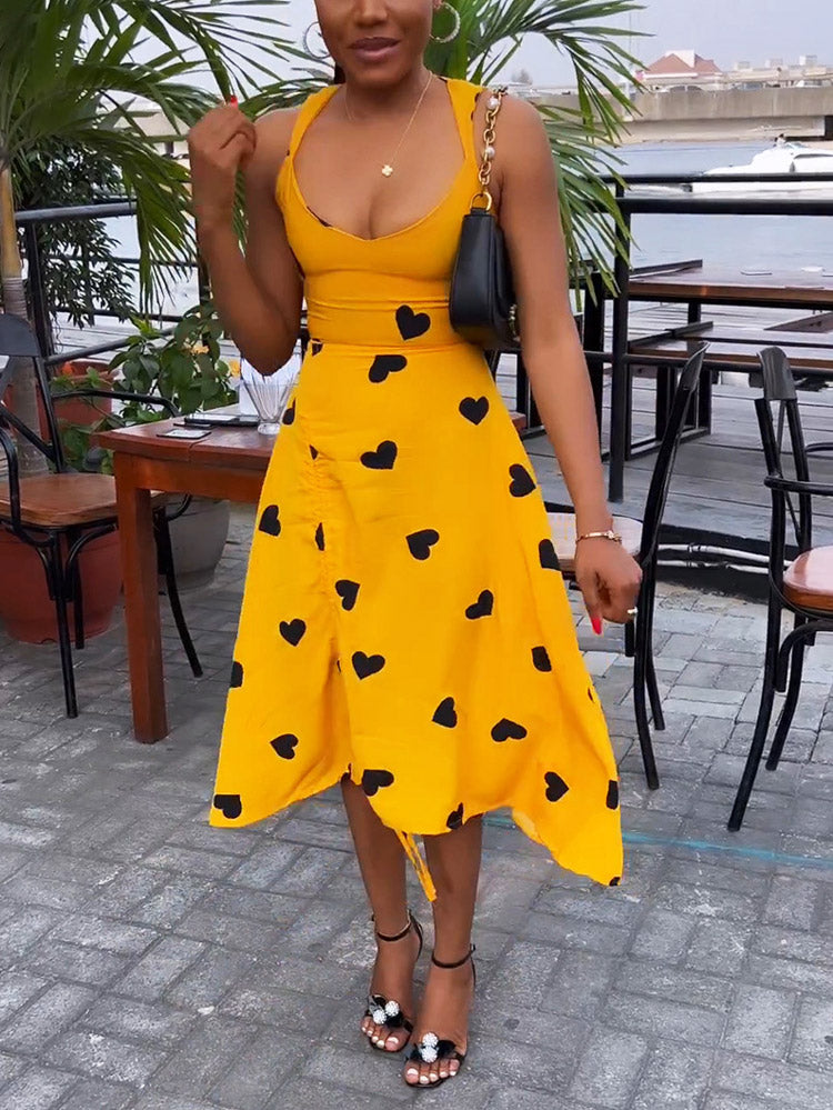 Front view of a woman in a yellow heart-print dress with ruched detailing.