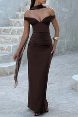 Front view of a woman in a dark brown off-the-shoulder formal gown with a sweetheart neckline and draped detailing, standing on stairs.