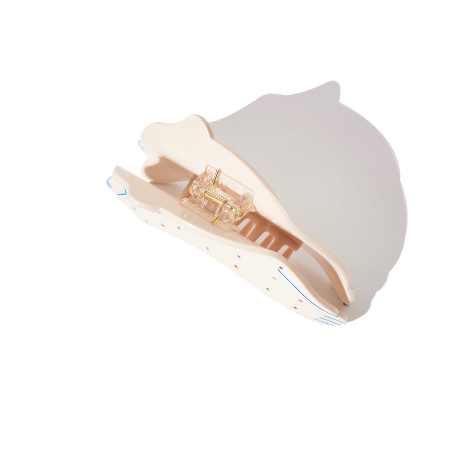 Cream dog-shaped hair claw with colorful polka dots and blue line details, showing the interior mechanism.