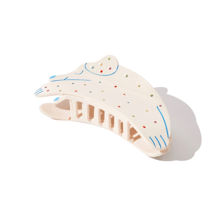 Cream dog-shaped hair claw with colorful polka dots and blue line details, shown from a 3/4 angle.
