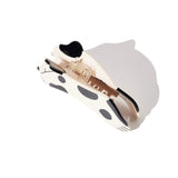White and black cow print cat claw hair clip, showing internal mechanism