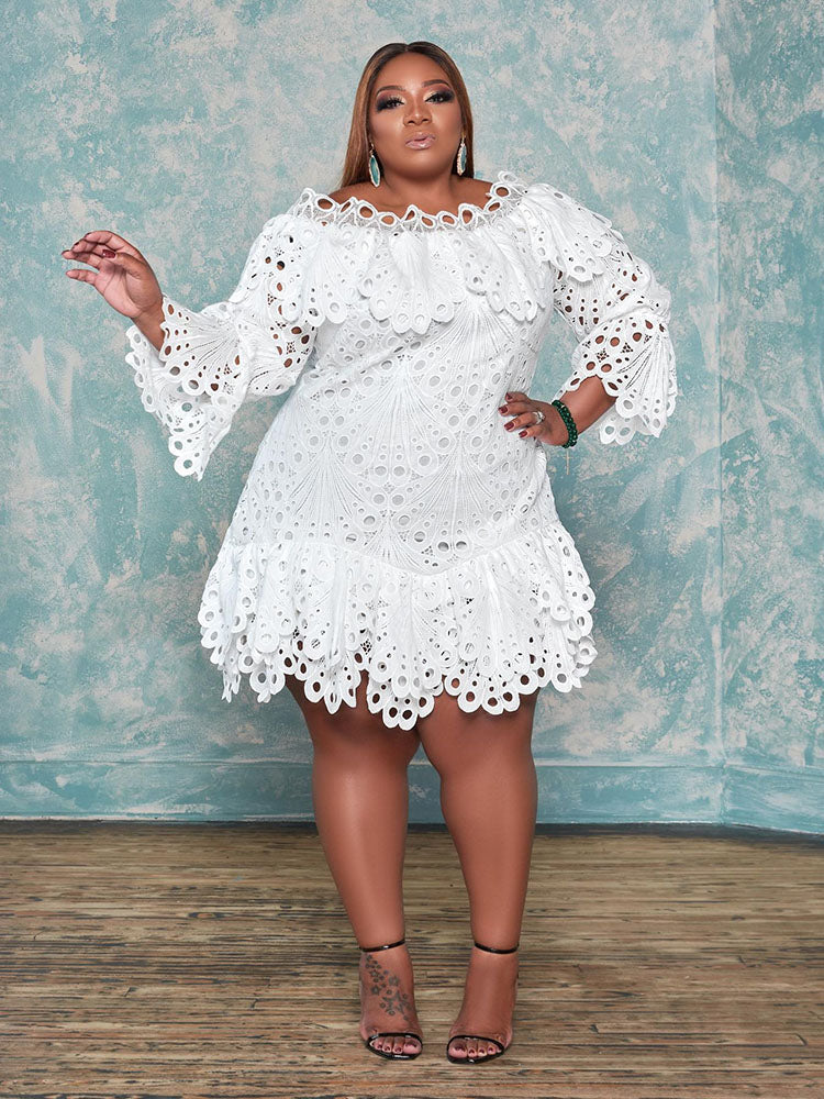 Plus size model wearing a white off-the-shoulder eyelet lace mini dress with bell sleeves and tiered skirt.