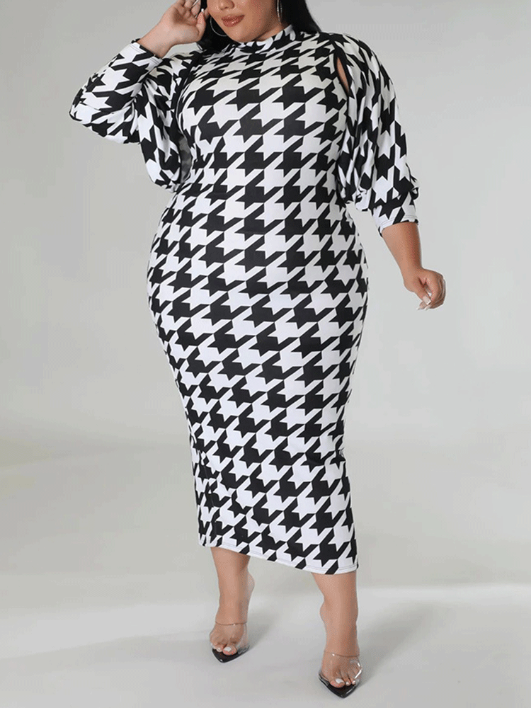 Plus size model posing in a black and white houndstooth print mock neck midi dress and a matching jacket