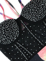 Close-up of the sparkling rhinestone embellishments on the black mesh bodice of a dress