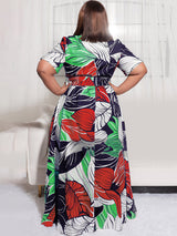 Back view of a woman wearing a floral print maxi dress with short sleeves.