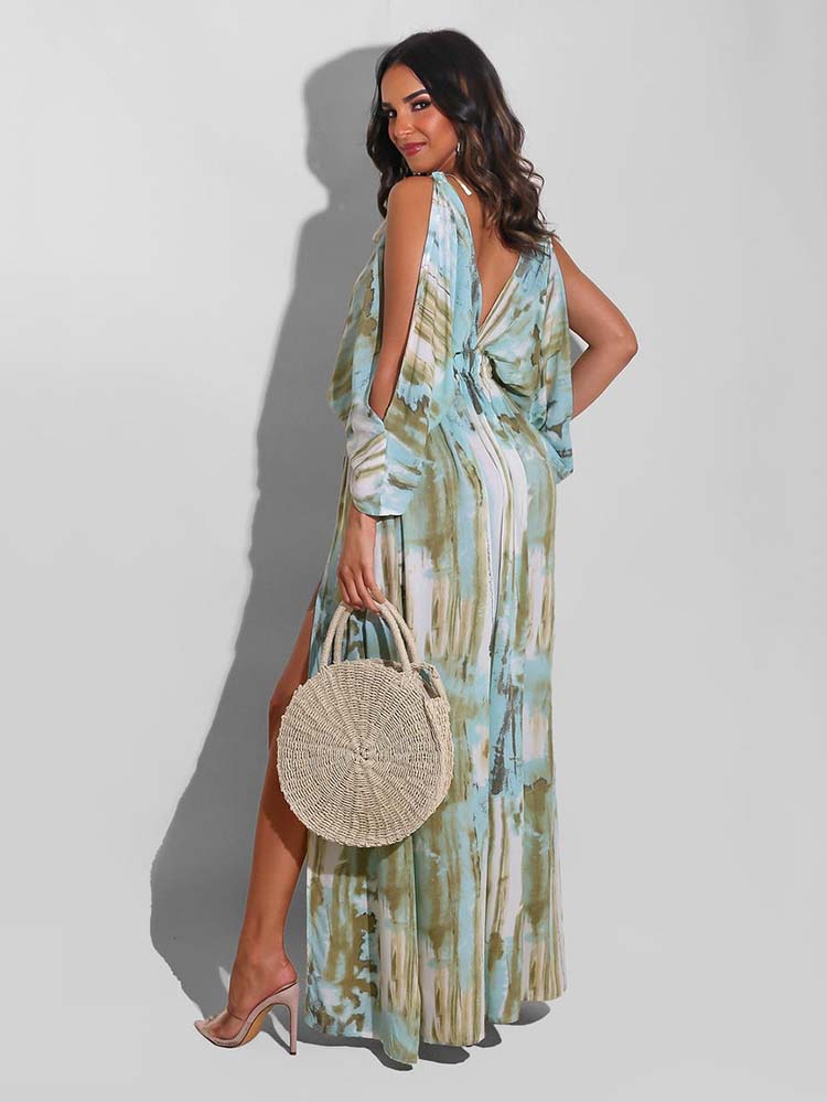 Back view of a woman in a tie-dye maxi dress with cold shoulder sleeves and a deep V-neck.