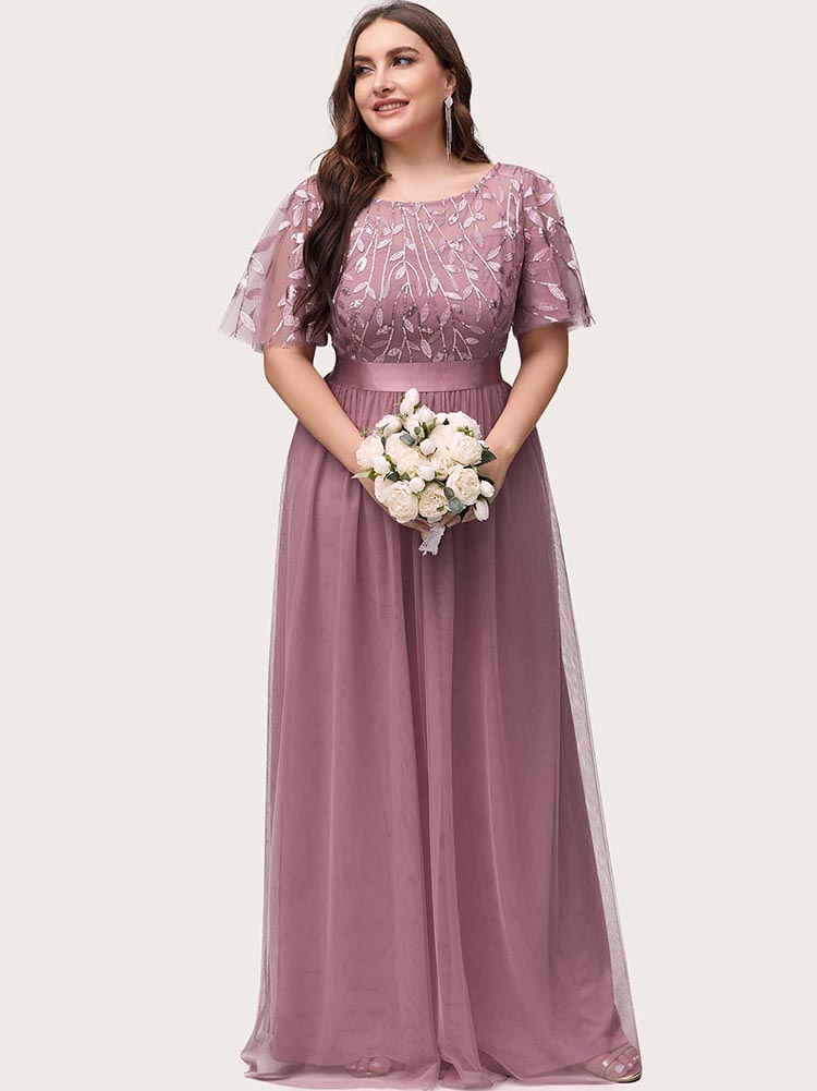 Woman wearing a dusty rose A-line maxi dress with embroidered flutter sleeves and a satin waistband, holding a bouquet.