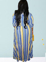 Back view of a woman wearing a blue, yellow, and white striped maxi dress with a belted waist.