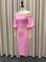 side view of pink sheath dress with asymmetrical neckline and balloon sleeves displayed on a mannequin
