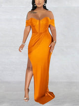 Woman wearing a floor-length golden yellow off-the-shoulder dress with a high slit