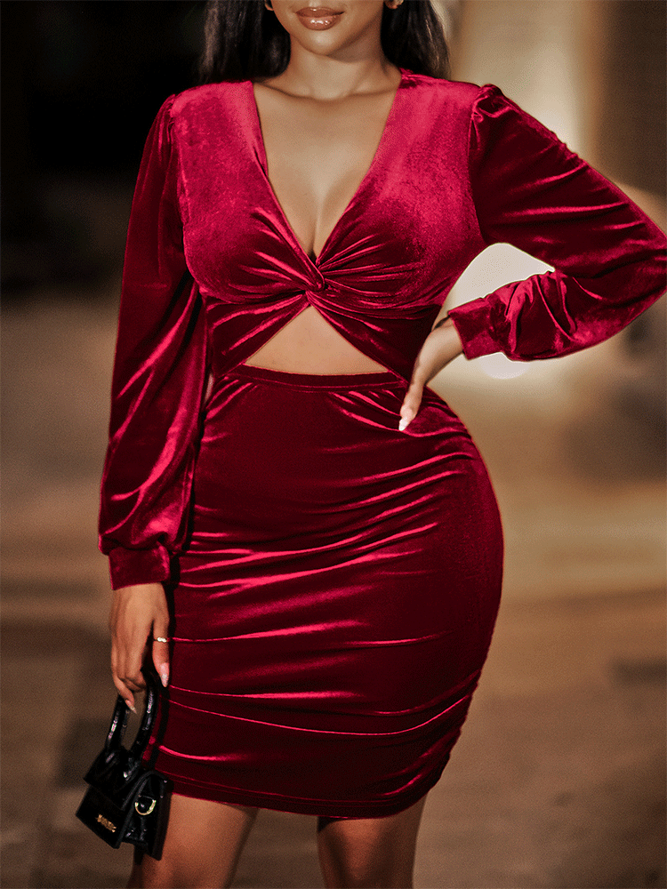 Woman wearing a deep red velvet bodycon dress with a v-neck, twist front detail, cut-out waist, ruched skirt, and long sleeves.