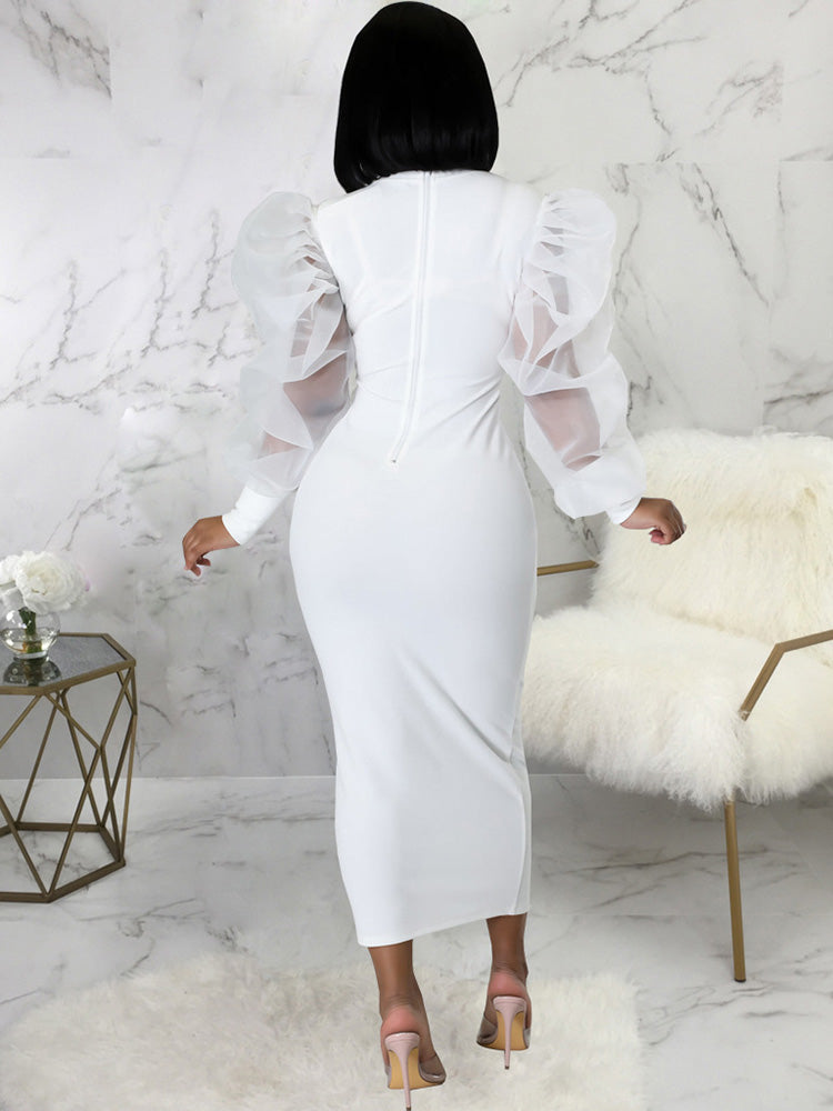 Back view of a woman in a white midi dress with sheer puff sleeves