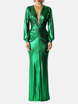 Studio-style shot of a woman in an elegant emerald green metallic dress with long sleeves, a ruched front, and a flattering column silhouette.