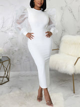 Woman wearing a white midi dress with sheer puff sleeves