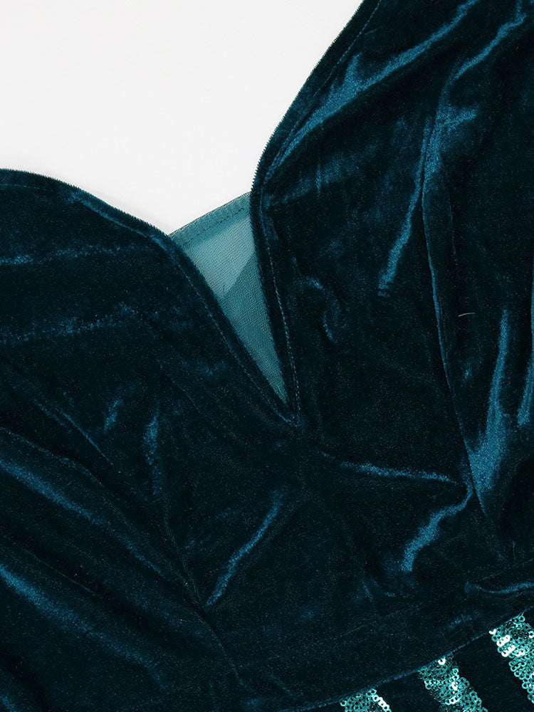 Close-up of the zipper on the back of a teal velvet dress.