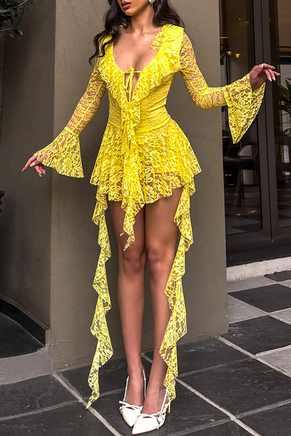 woman wearing a yellow lace dress with bell sleeves and an asymmetrical hemline